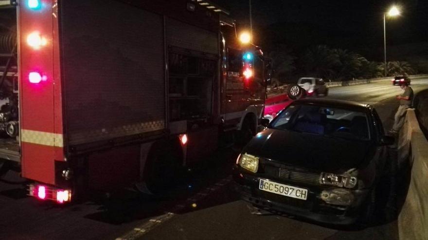 Uno de los dos cohes accidentados junto al camión de los bomberos.