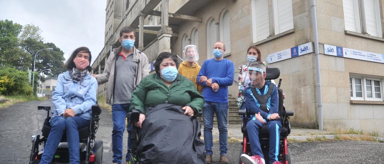 Usuarios de Amencer-Aspace, acompañados de dos trabajadores de la entidad, ayer, frente al edificio Centro Sur que albergará la futura residencia/ Rafa Vázquez