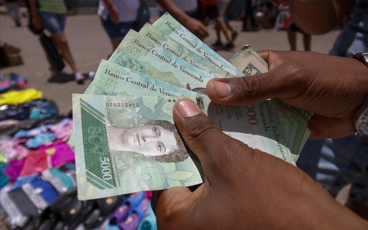zentauroepp44705667 a venezuelan man shows venezuelan bolivar bills as she sells180820122925