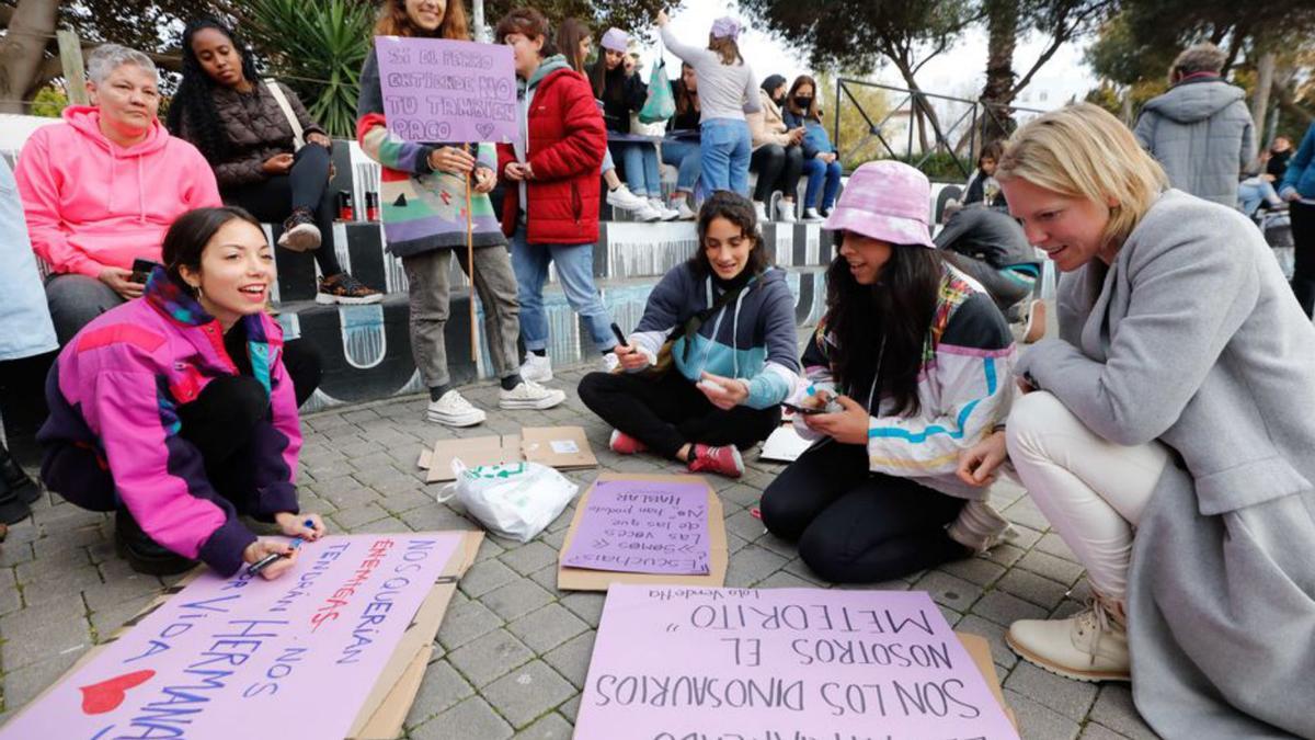 Un grupo de mujeres escriben lemas en pancartas, en el parque de la Paz. 