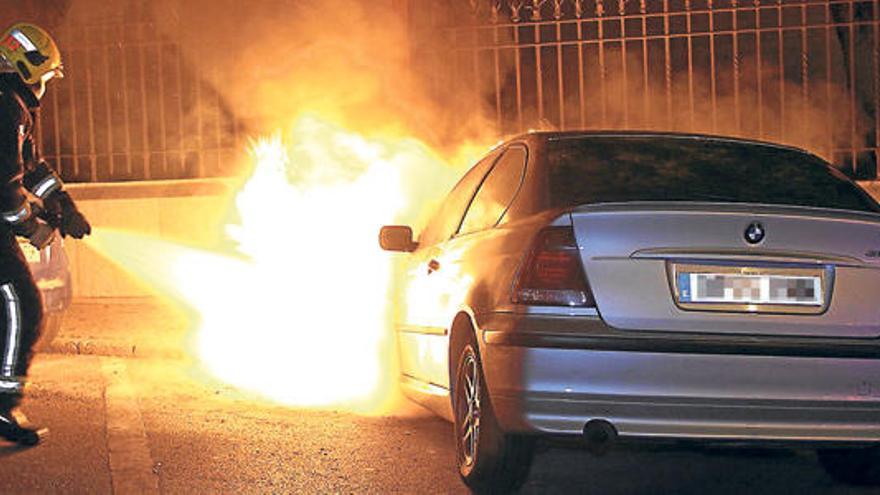 Un bombero arroja agua sobre las llamas, que destrozaron la parte delantera del coche.