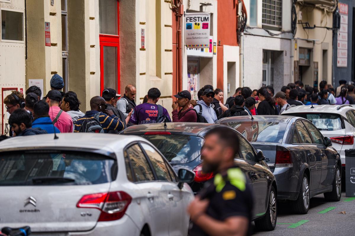 Caos y una larga cola de personas que esperan regularizar su situación en España en la Oficina de Benestar Social i Família de Barcelona-Sants/Eixample.