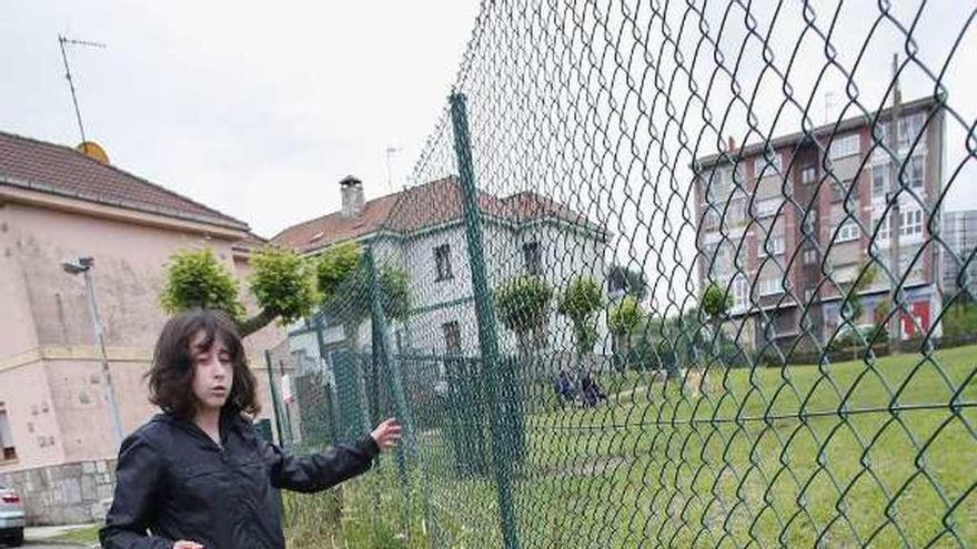 Virginia Lozano muestra los maderos que se han colocado para evitar los huecos en la valla.