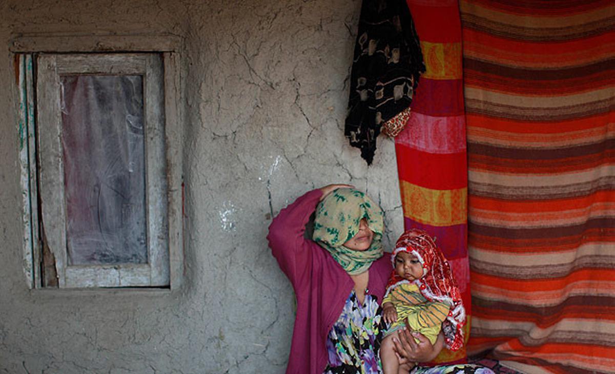 Una dona afganesa i la seva filla de 5 anys, a les portes de casa seva en un barri pobre de Kabul.