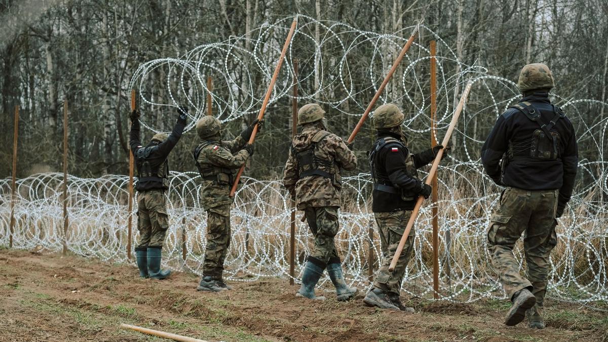 Soldados del ejército polaco arreglan bobinas de alambre de púas en una valla a lo largo de la frontera polaca, con el enclave ruso de Kaliningrado, cerca de Zerdziny, Polonia