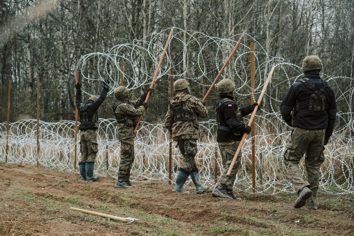 Soldados del ejército polaco arreglan bobinas de alambre de púas en una valla a lo largo de la frontera polaca, con el enclave ruso de Kaliningrado, cerca de Zerdziny, Polonia