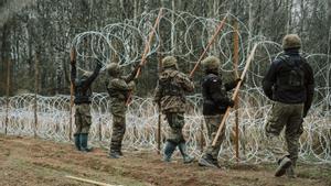 Soldados del ejército polaco arreglan bobinas de alambre de púas en una valla a lo largo de la frontera polaca, con el enclave ruso de Kaliningrado, cerca de Zerdziny, Polonia