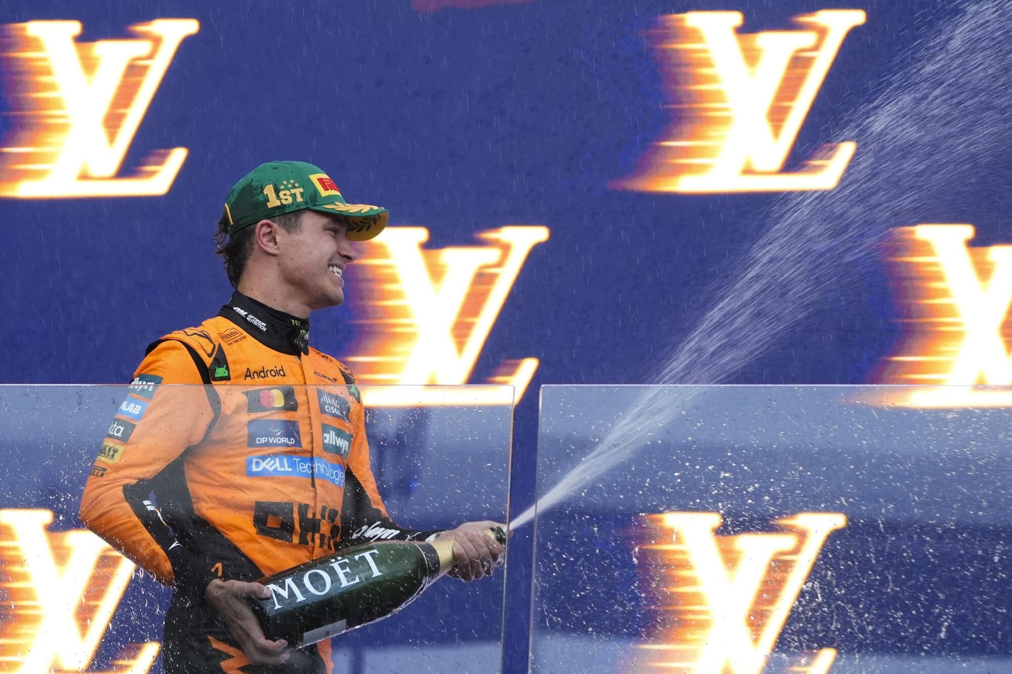 McLaren driver Lando Norris of Britain celebrates on the podium after winning the Australian Formula One Grand Prix at Albert Park, in Melbourne, Australia, Sunday, March 16, 2025. (AP Photo/Asanka Brendon Ratnayake)