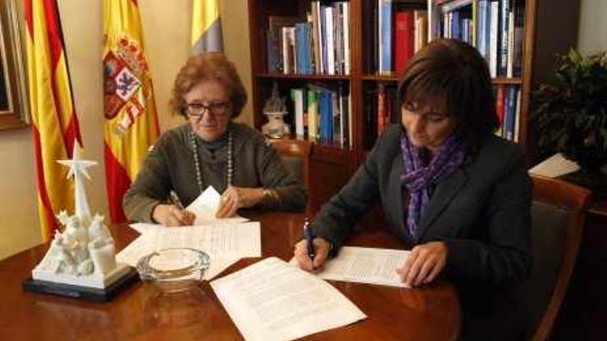 María del Carmen Pérez y Mayte Parra firmando el convenio.