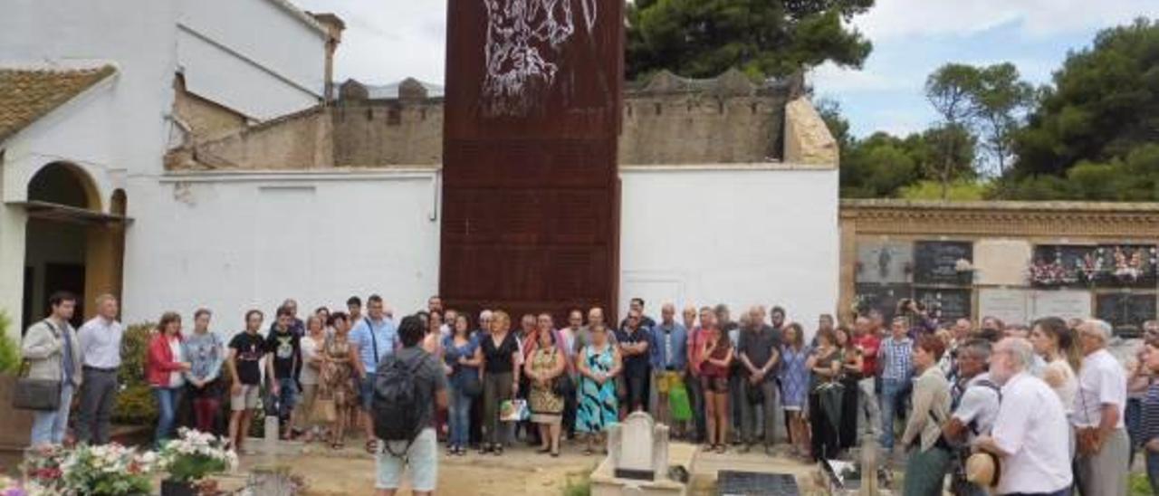 Mezquida explica a la expedición olivense las características de las fosas, ayer en el cementerio de Paterna, ante el memorial de las víctimas.