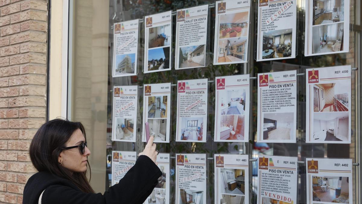 Una joven examina la oferta de una inmobiliaria en València.