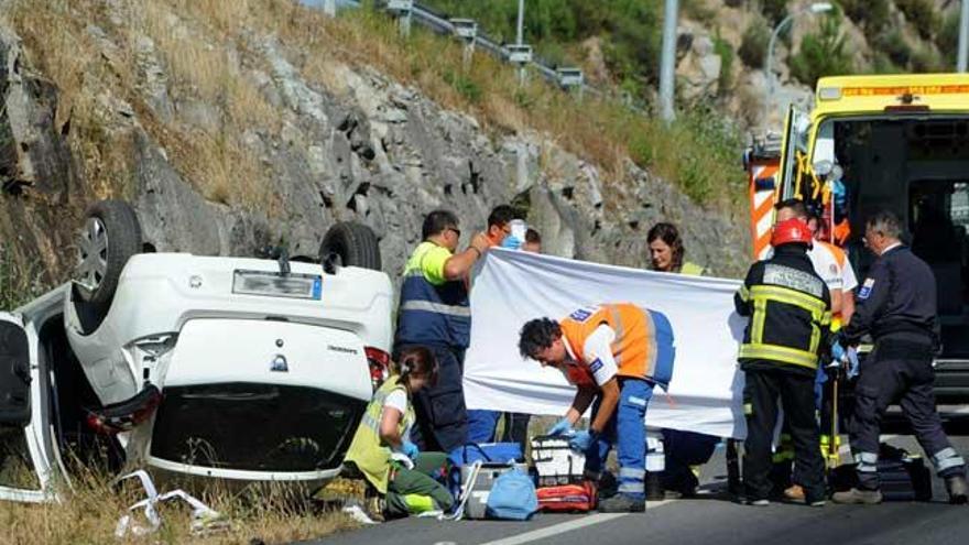 Los servicios médicos intentan reanimar al conductor junto al vehículo volcado. // Iñaki Abella