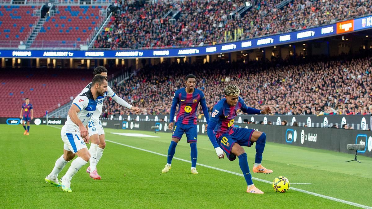 Lamine Yamal controla un balón en la banda izquierda junto a Balde.