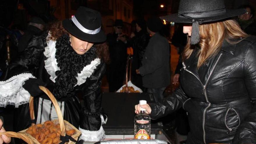 Reparto de rosquillas y anís durante el entierro de la Sardina, en las fiestas de Carnaval de Luarca.