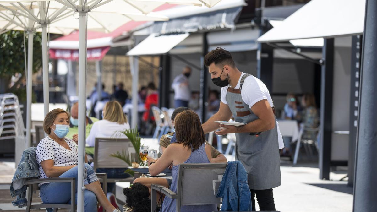 Un grupo de personas disfruta del buen tiempo en una terraza.