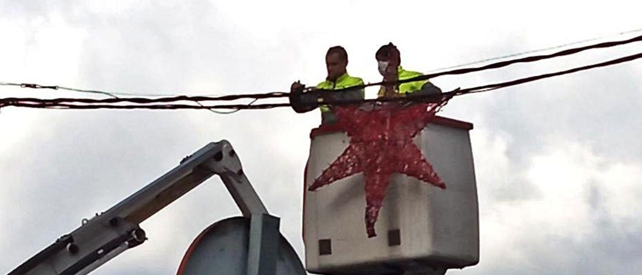 Un grupo de operarios, ayer, colocando luces en Moreda. | Camporro