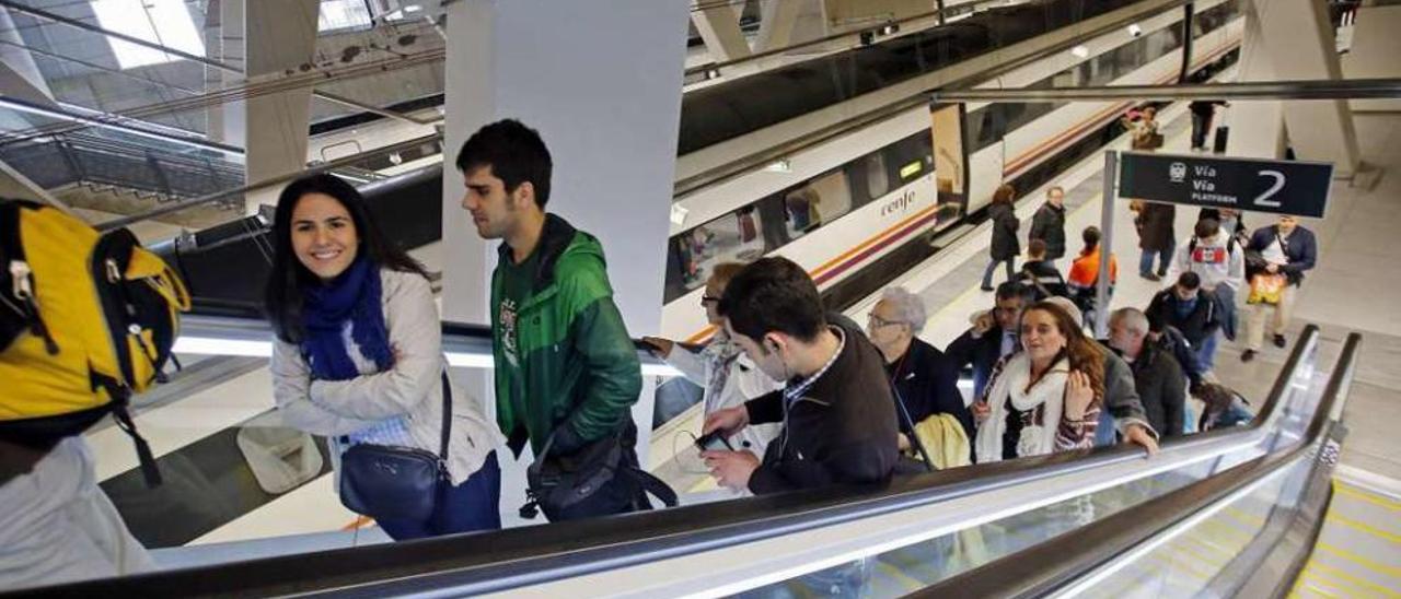 Un grupo de pasajeros abandona la estación de Urzáiz que acoge el tren del Eje Atlántico. // Marta G. Brea