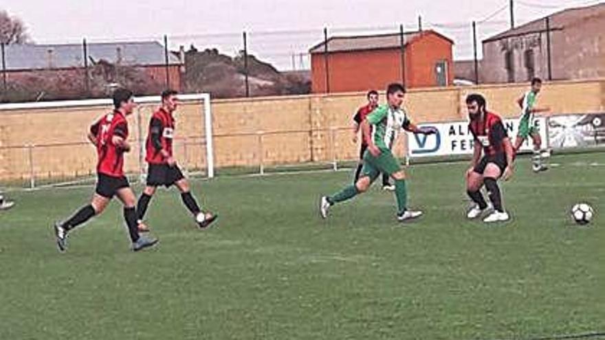 Varios jugadores pugnan por un balón suelto.