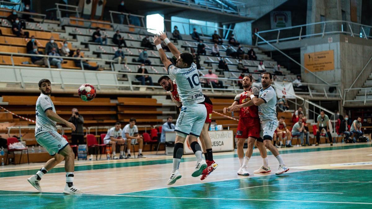 Quintas trata de blocar un lanzamiento de un jugador oscense.