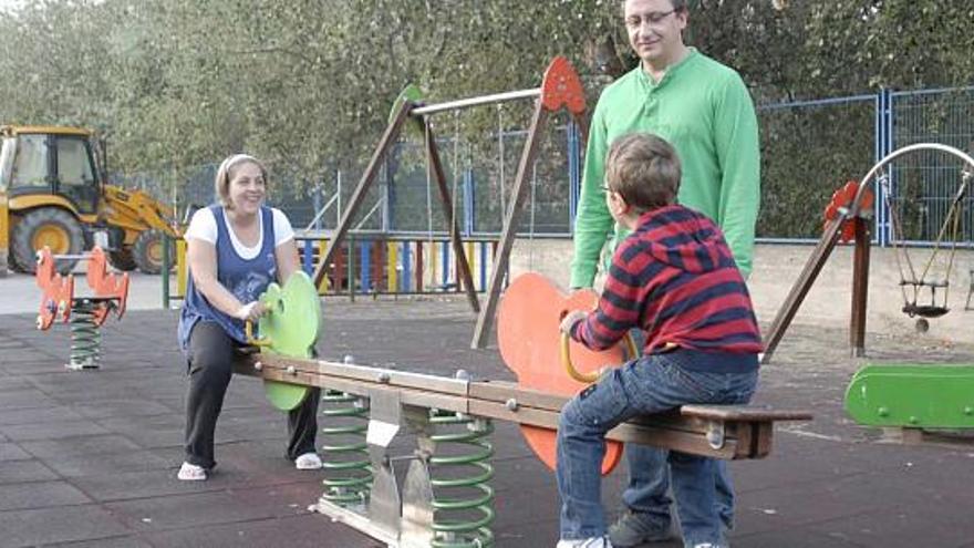 Uno de los alumnos con problemas motores juega con sus padres en el parque frente a su casa, en una imagen tomada ayer.