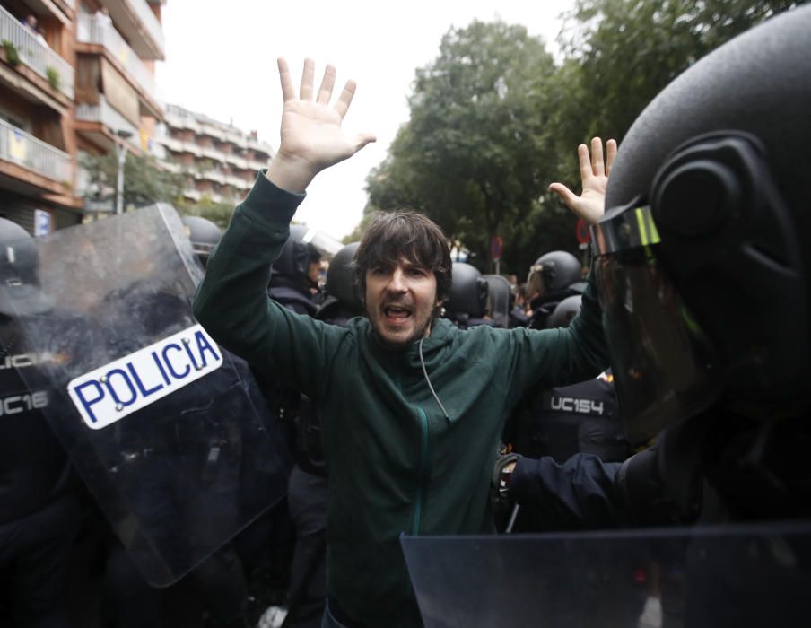 Manifestante rodeado por varios agentes policiales.