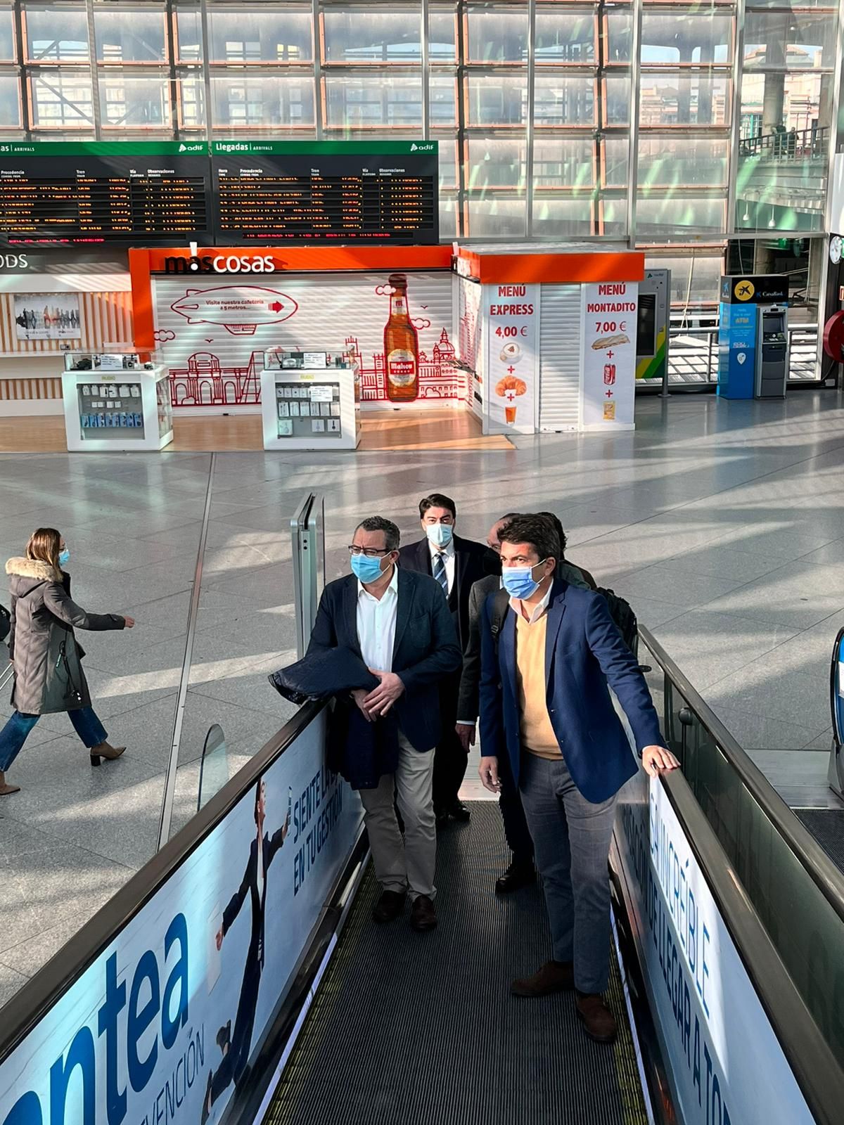 La delegación de alcaldes populares subiendo por una escalera mecánica en Puerta de Atocha