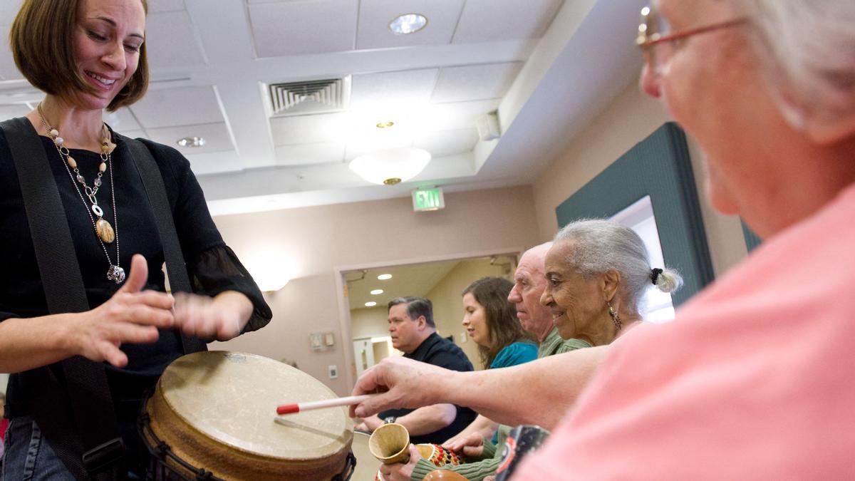 (FILES) In this file photo music therapist Heather Davidson (L) plays a drum with Claire Diering (R) during a drum circle with patients with Alzheimer’s disease at the Copper Ridge Care Center in Sykesville, Maryland, on October 23, 2009. - The United States on June 7, 2021 approved a drug called Aduhelm to treat patients with Alzheimer’s, the first new medicine against the disease in almost two decades and the first to address cognitive decline linked to the condition. The decision was highly anticipated but also contentious, because an independent expert panel convened by the regulatory Food and Drug Administration last November found insufficient evidence of Aduhelm’s benefit. (Photo by Saul LOEB / AFP)