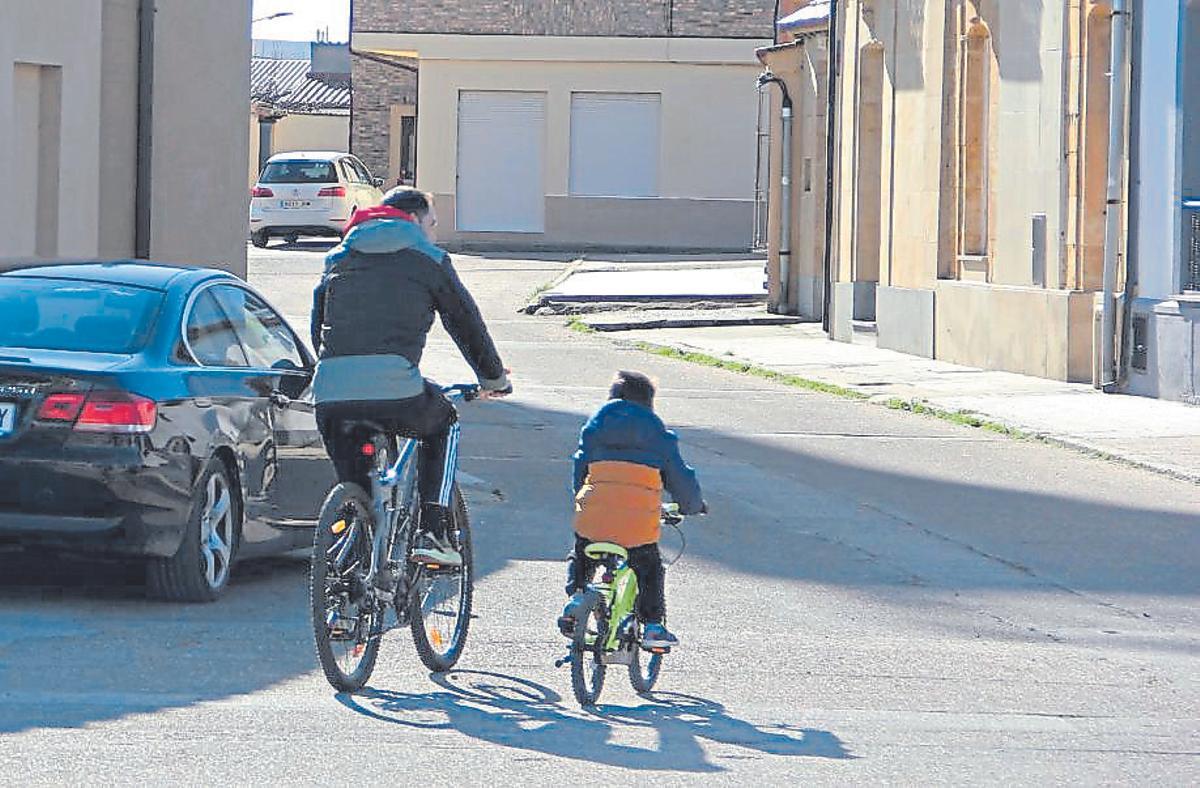 Un padre y su hijo pasean en bici por Moraleja del Vino