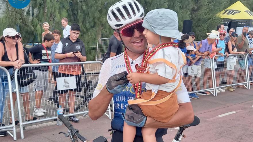 Antonio Padrón García, campeón de la carrera FudeNas 2023, a su llegada a la meta en Morro Jable con su hijos Liam en brazos. | | ONDA FUERTEVENTURA