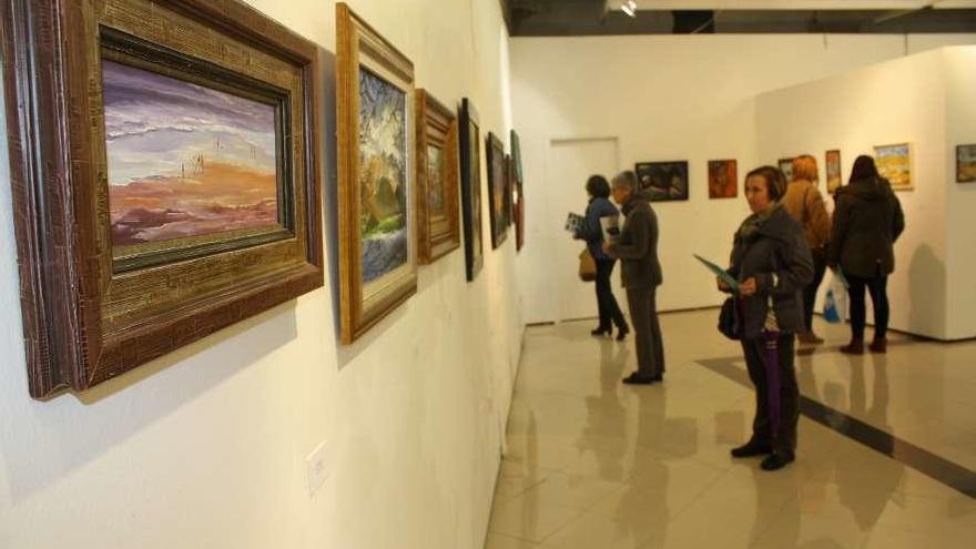 Visitantes en una exposición en la sala Álvaro Delgado de Luarca.