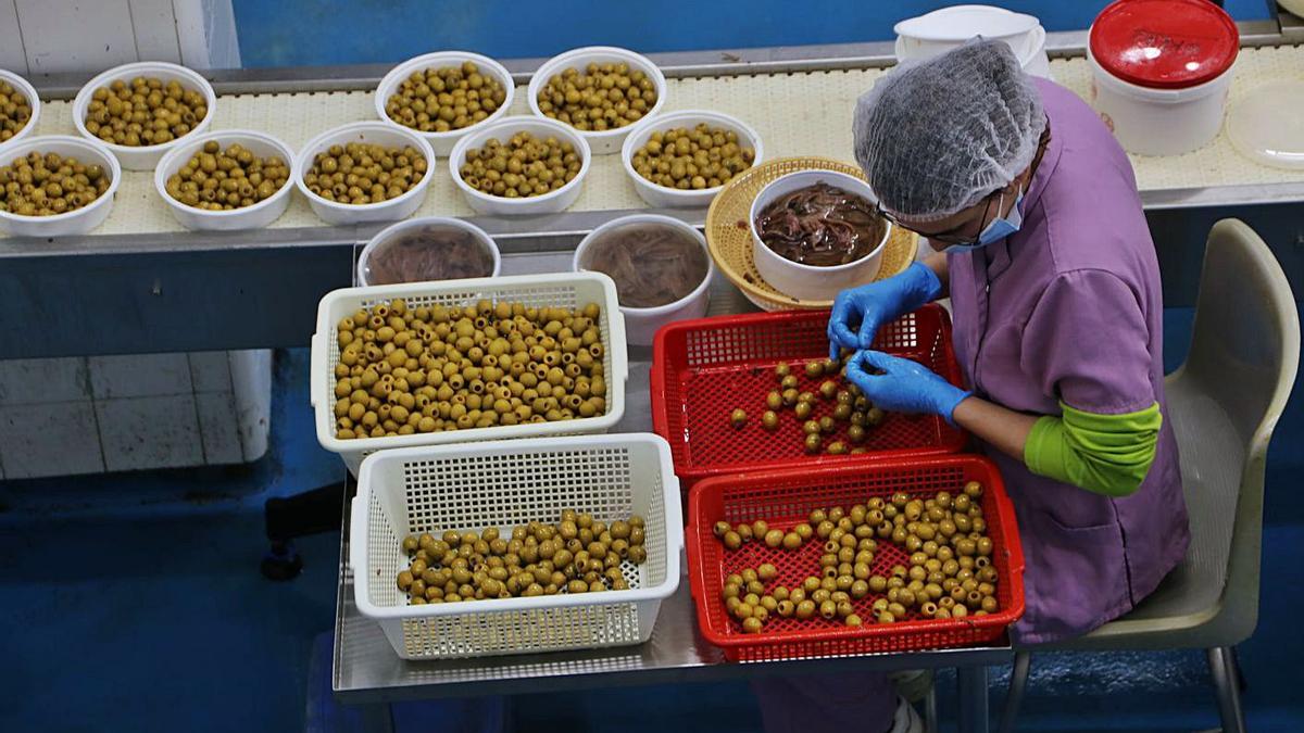Una treballadora omple olives amb anxoves, ahir, a la fàbrica el Xillu.  | BASILI GIRONÈS