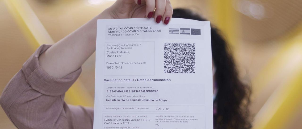 Una mujer muestra un certificado Covid.