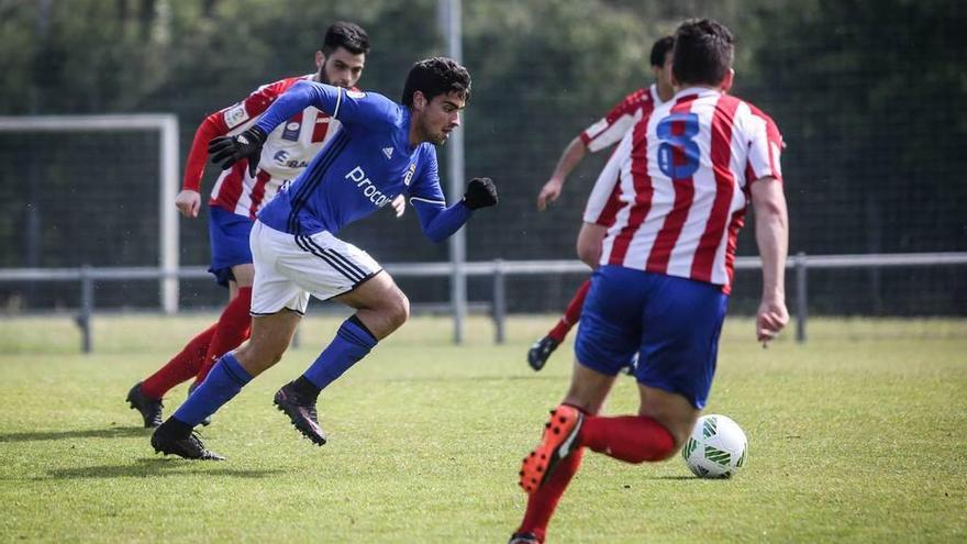 El jugador del Oviedo B David Álvarez trata de irse de tres rivales de L&#039;Entregu.