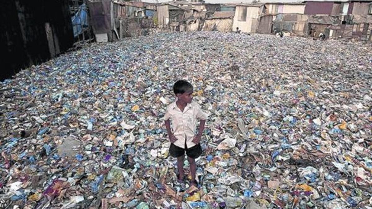 Abandonado 8 Un niño indio, rodeado de montones de plásticos procedentes de una planta de reciclaje, en una zona de chabolas de Bombay.