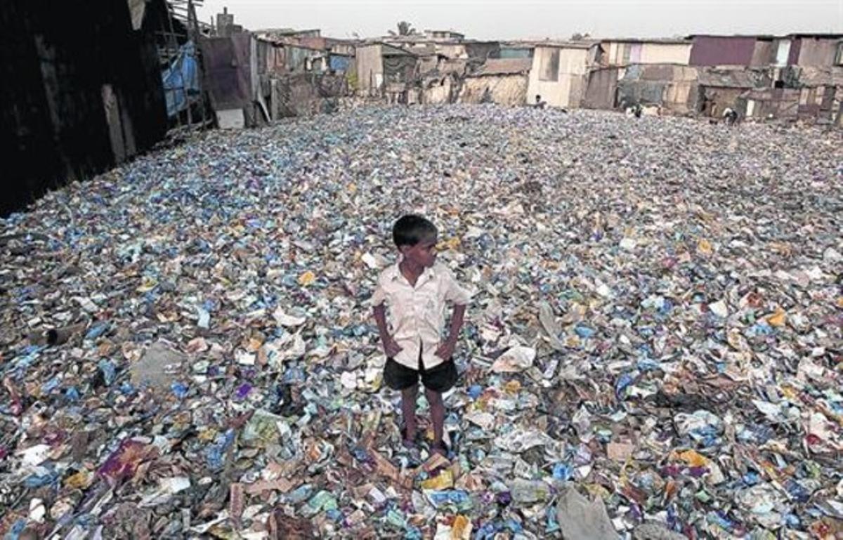 Abandonat 8 Un nen indi, envoltat de munts de plàstics procedents d’una planta de reciclatge, en una zona de barraques de Bombai.