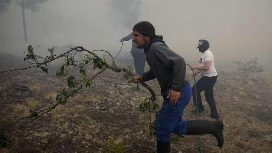 Dos de los jóvenes que lucharon con su propios manos contra el fuego (d.), ayer, en un monte de A Regueira Grande, en Vilamarín.  // B.Lorenzo