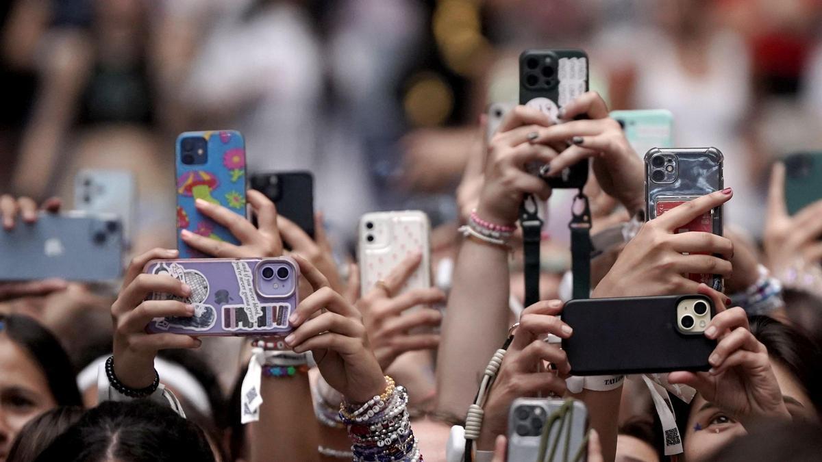Los asistentes a un concierto, usando sus móviles
