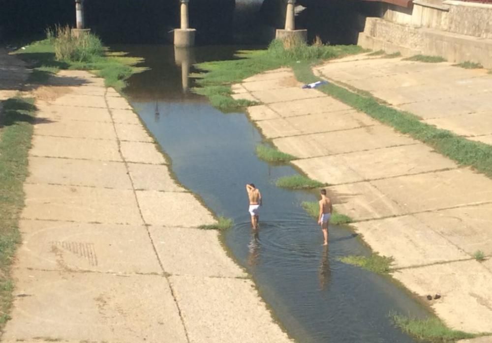 Dos joves s''han refrescat aquest dimecres a les aigües de l''Onyar al centre de Girona