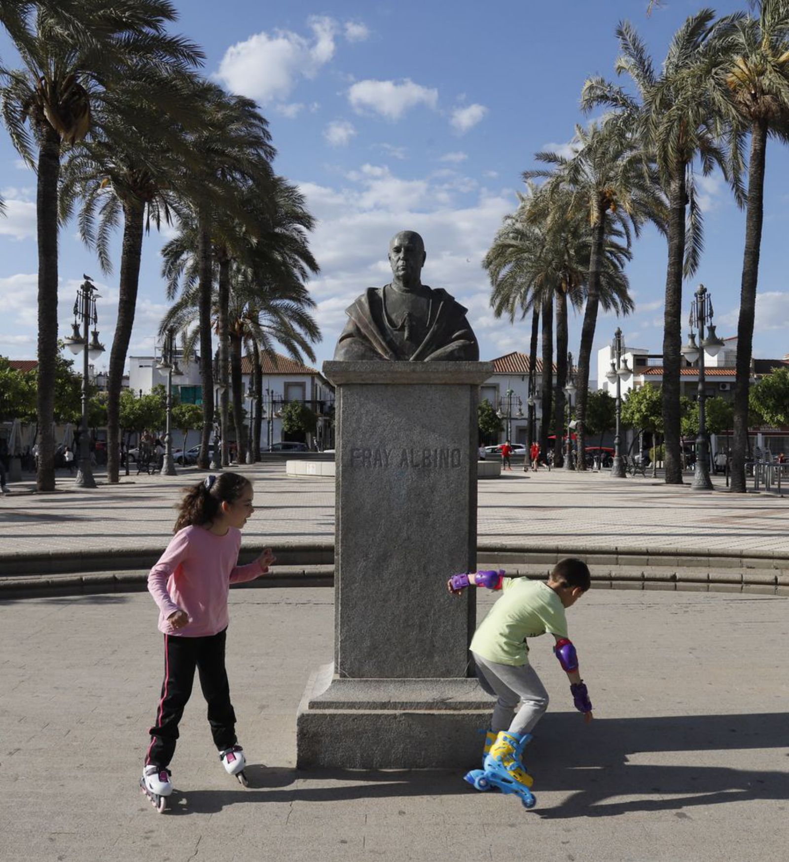 Dos niños juegan junto a la estatua de Fray Albino.