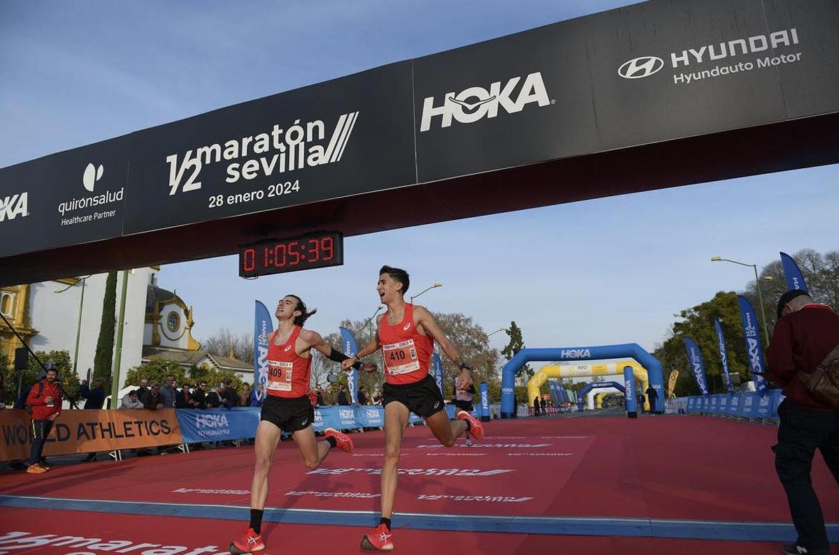 Diego Menéndez, a la izquierda, entra en la meta en la media maratón de Sevilla.