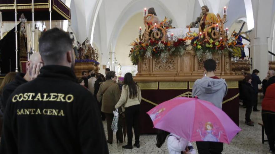 Cofrades ante el trono de la Santa Cena en San Juan Bautista.