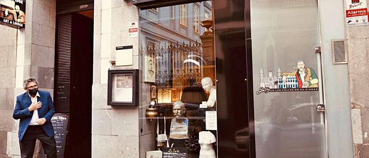 Miguel López señalando el escaparate de su restaurante Pompidou.