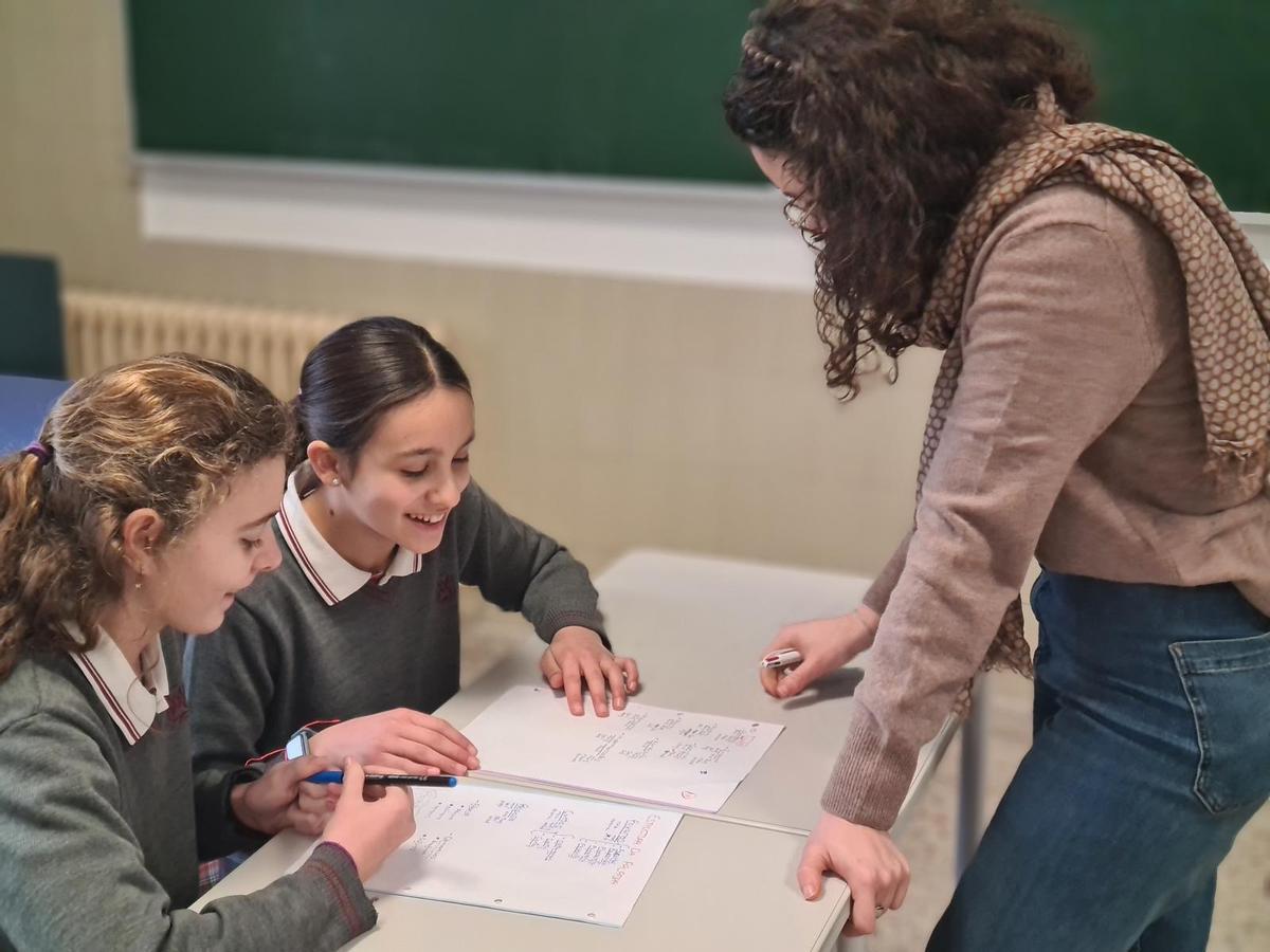 Unha maestra ensinando conceptos a dúas alumnas da escola compostelá.