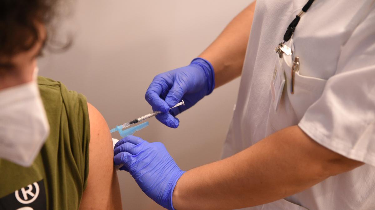 Una sanitaria vacunando a un adolescentes.