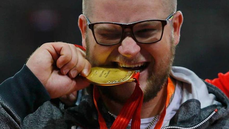 Pawel Fajdek muerde su medalla de oro.