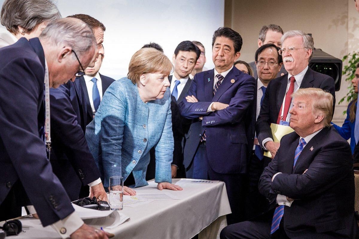 May, Macron y Merkel abordan a Trump durante la cumbre del G7 en 2018.