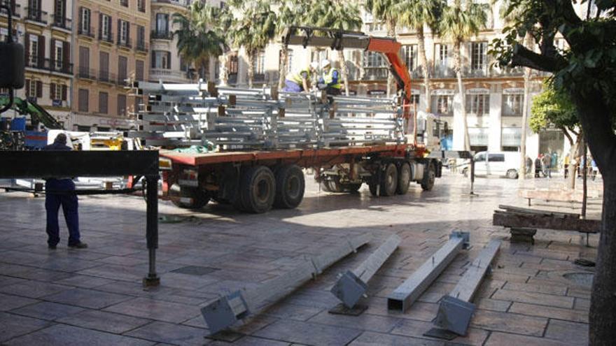 Operarios desmontan la tribuna de Semana Santa de Málaga.