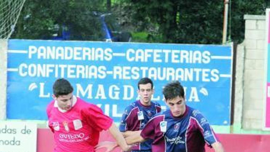 Longi conduce el balón presionado por un rival del Astur.