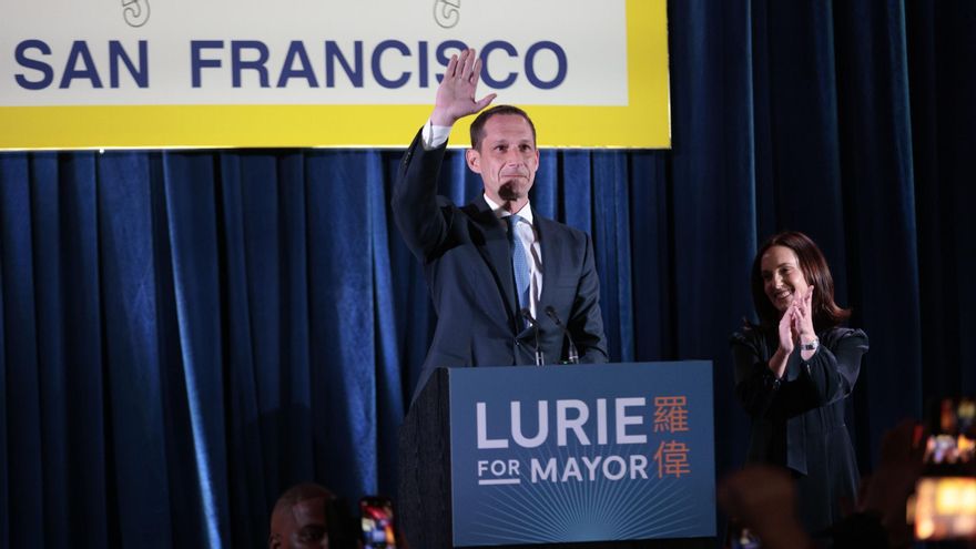 El candidato a la alcaldía Daniel Lurie, en el centro, saluda durante su fiesta de la noche electoral en San Francisco.