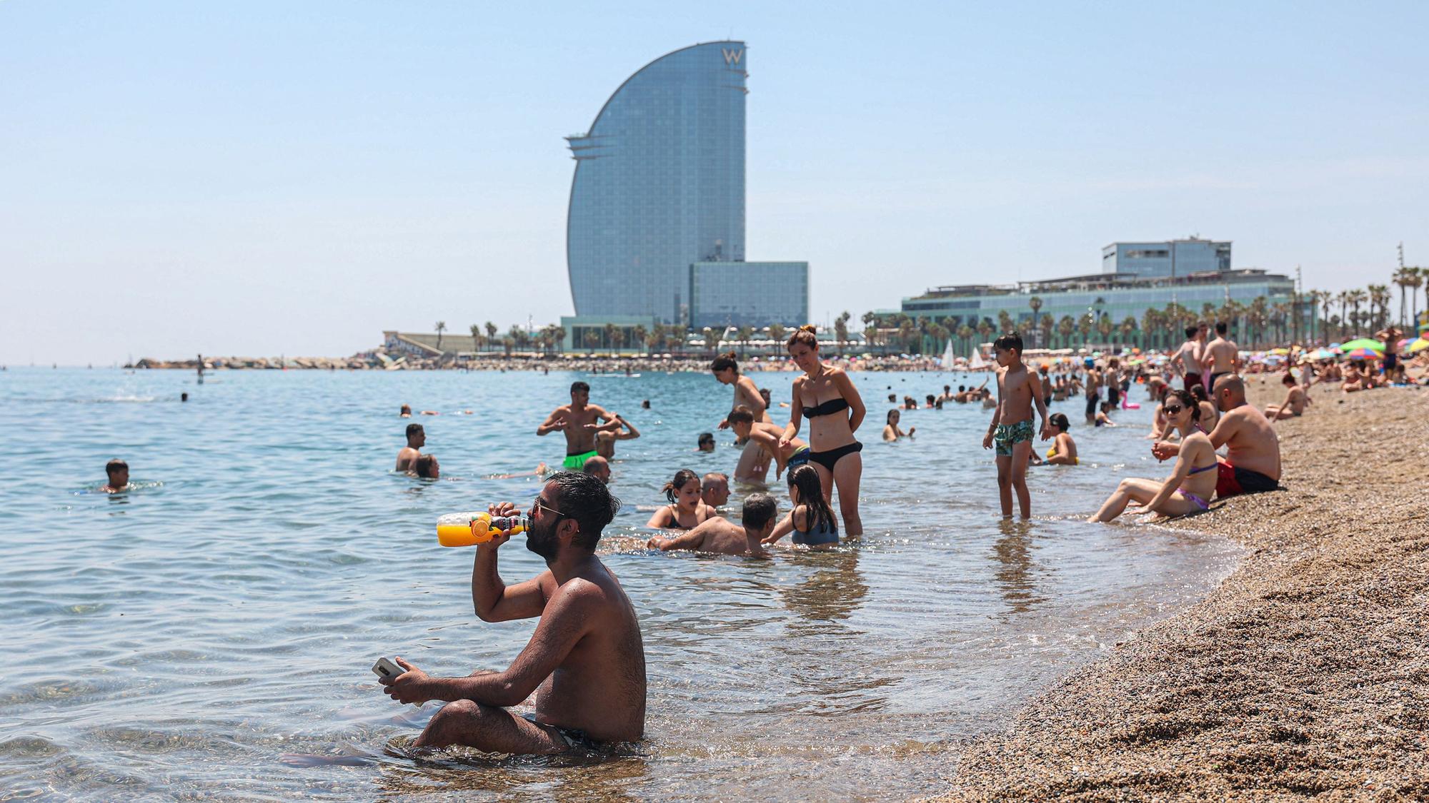 Soportando las altas temperaturas en la playa de la Barceloneta este mediodía